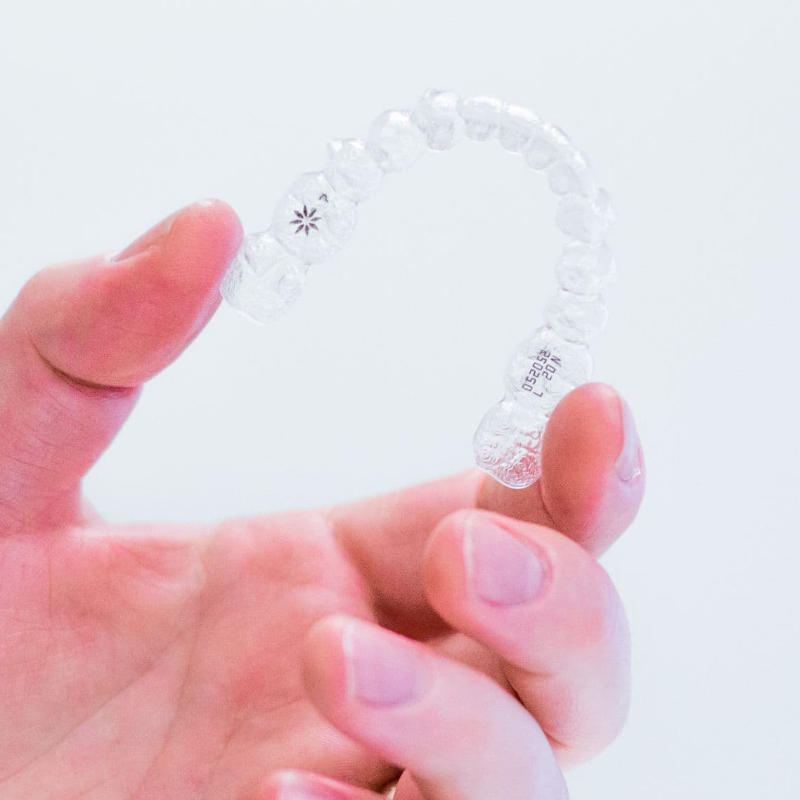 clear invisalign aligners in hand